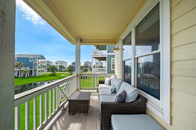 balcony with a water view and an outdoor hangout area