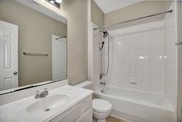 full bathroom with toilet, vanity, and bathing tub / shower combination