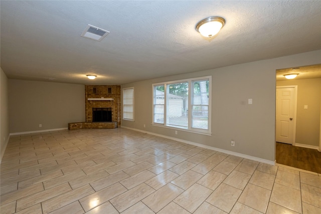 unfurnished living room featuring a textured ceiling, light tile patterned floors, and a fireplace