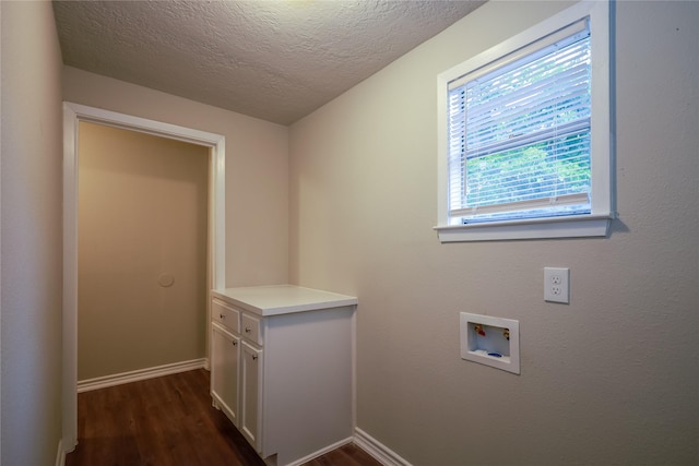 laundry area with hookup for a washing machine, a textured ceiling, cabinets, and dark hardwood / wood-style flooring