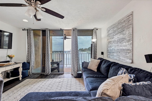 living room with hardwood / wood-style flooring, a textured ceiling, expansive windows, and ceiling fan