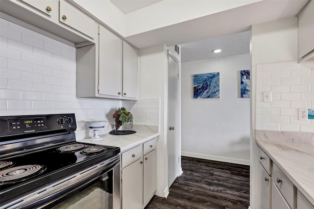 kitchen with dark hardwood / wood-style flooring, backsplash, black / electric stove, white cabinetry, and light stone counters