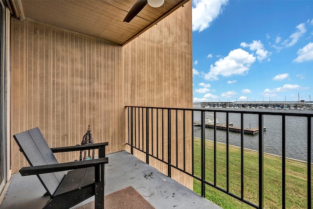 balcony with ceiling fan and a water view