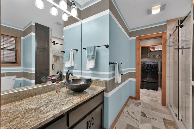 bathroom featuring toilet, an enclosed shower, ornamental molding, vanity, and washer and clothes dryer
