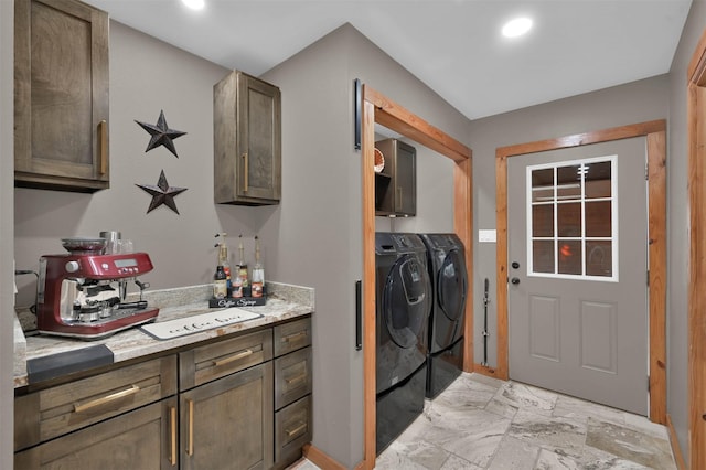 washroom with cabinets, independent washer and dryer, and indoor bar
