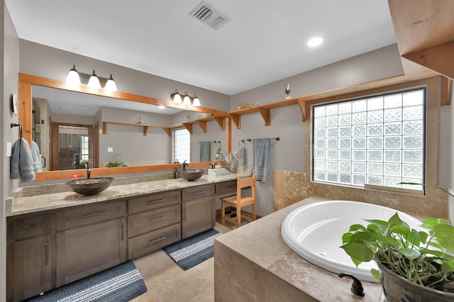 bathroom featuring tiled tub and vanity