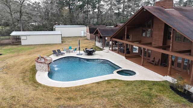 view of pool featuring a patio area, a wooden deck, a yard, an outdoor structure, and an in ground hot tub