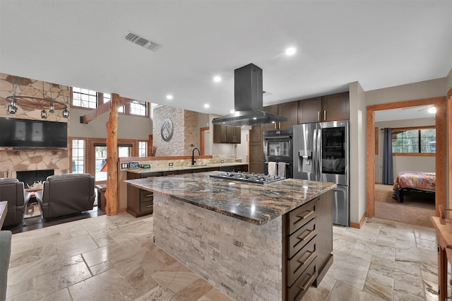 kitchen with appliances with stainless steel finishes, a center island, sink, and island range hood