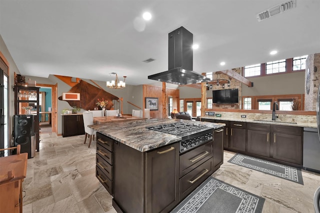 kitchen with sink, appliances with stainless steel finishes, dark brown cabinetry, island range hood, and light stone countertops