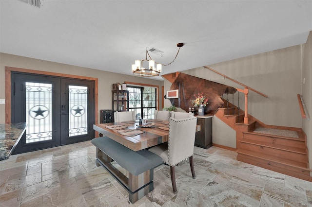 dining area with an inviting chandelier and french doors