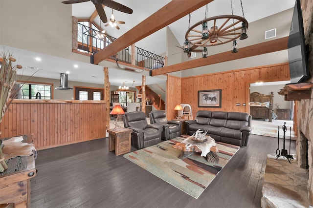 living room with beamed ceiling, ceiling fan, dark hardwood / wood-style flooring, and wood walls