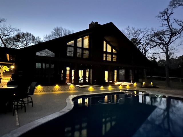 back house at dusk with a patio area