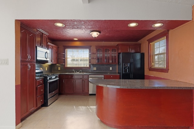 kitchen featuring tasteful backsplash, stainless steel appliances, and kitchen peninsula