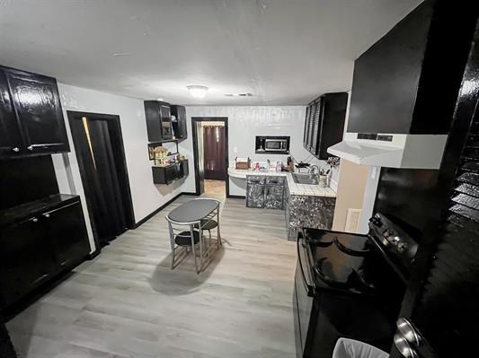 kitchen featuring sink, electric range, light hardwood / wood-style flooring, and built in microwave