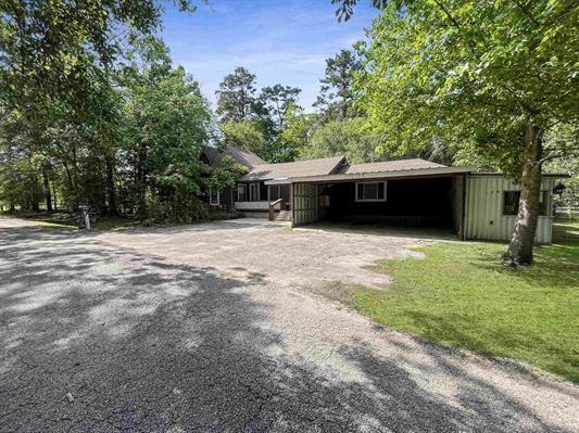 ranch-style home featuring a front lawn and a carport