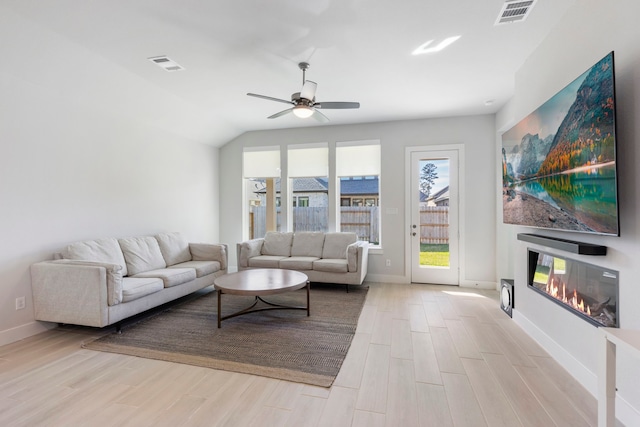 living room featuring lofted ceiling, ceiling fan, and light hardwood / wood-style flooring