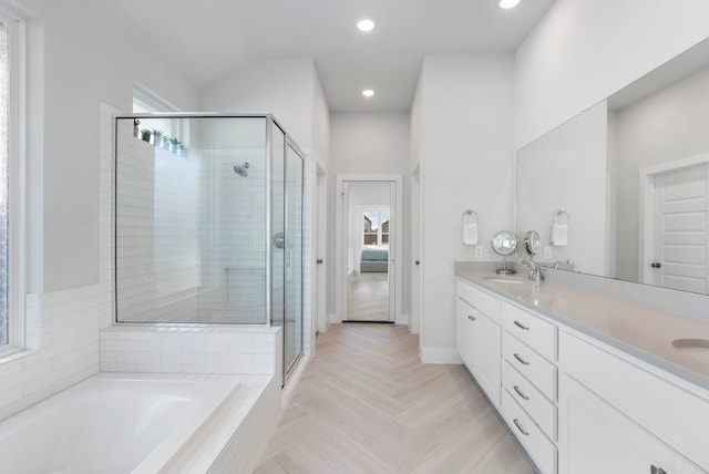 bathroom with vanity, parquet flooring, and plus walk in shower