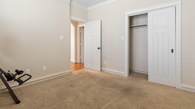 unfurnished bedroom with ornamental molding, a closet, and carpet