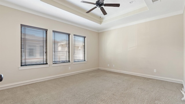 carpeted empty room with crown molding, ceiling fan, and a raised ceiling