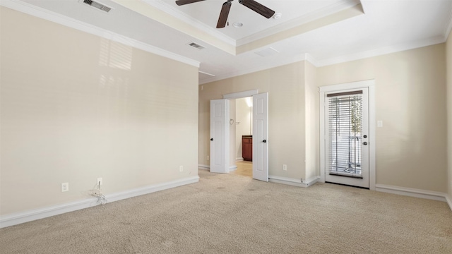 carpeted empty room featuring ornamental molding, ceiling fan, and a tray ceiling