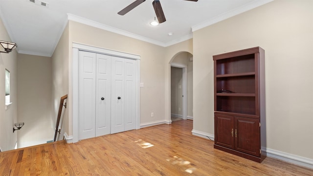 unfurnished bedroom featuring crown molding, ceiling fan, a closet, and light hardwood / wood-style flooring