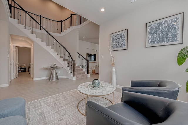 living room featuring wood-type flooring and a high ceiling