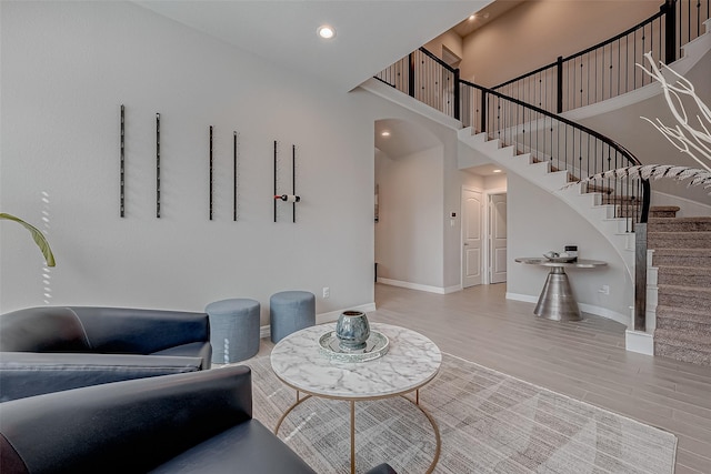 living room featuring hardwood / wood-style flooring and a towering ceiling