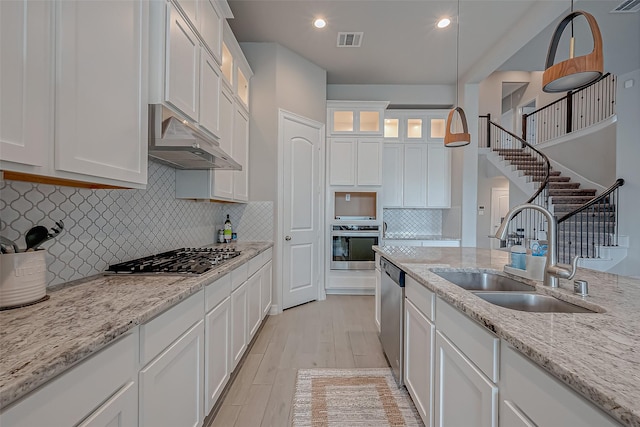 kitchen with white cabinetry, appliances with stainless steel finishes, sink, and decorative light fixtures