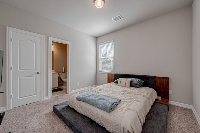 carpeted bedroom featuring ensuite bath