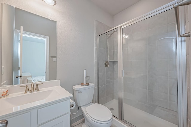 bathroom featuring vanity, toilet, and a shower with shower door