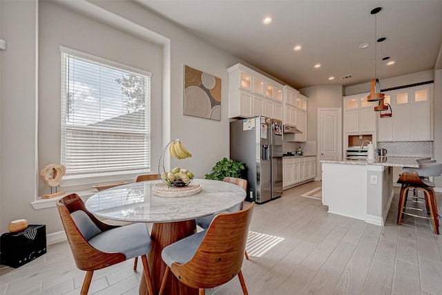 dining area with sink and light hardwood / wood-style flooring