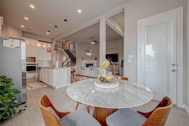 dining area with sink, light hardwood / wood-style floors, and ceiling fan