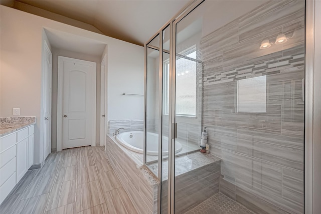 bathroom featuring lofted ceiling, vanity, and independent shower and bath