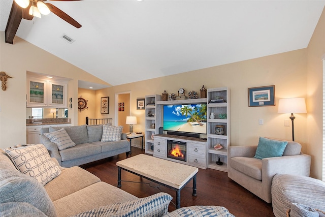 living room featuring ceiling fan, dark hardwood / wood-style flooring, and vaulted ceiling with beams