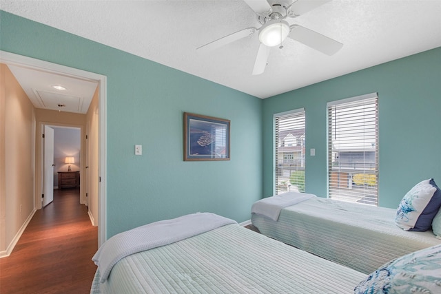 bedroom with ceiling fan, a textured ceiling, and dark hardwood / wood-style flooring