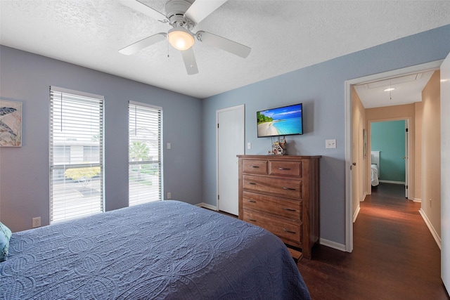 bedroom with ceiling fan, dark wood-type flooring, and a textured ceiling