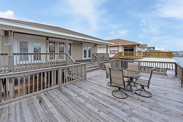 wooden deck featuring a water view and french doors