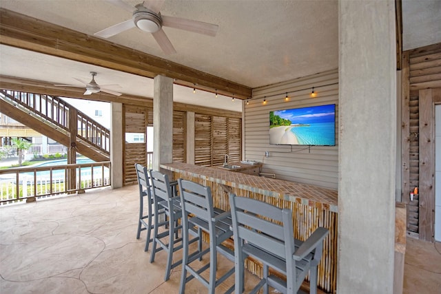 view of patio featuring an outdoor bar and ceiling fan