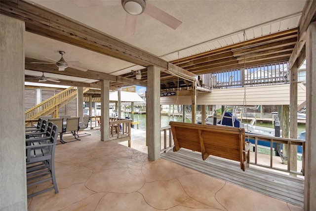 view of patio / terrace with ceiling fan and a water view