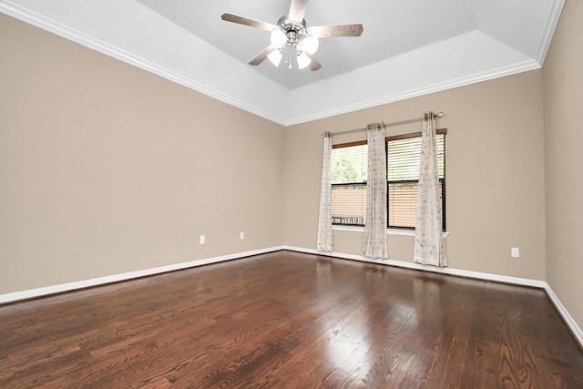 empty room with hardwood / wood-style flooring, ceiling fan, ornamental molding, and a tray ceiling