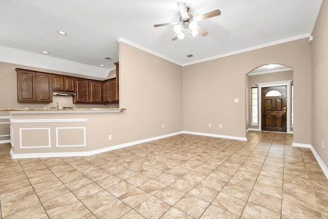 unfurnished living room featuring ceiling fan, crown molding, and light tile patterned flooring