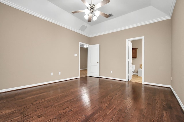 unfurnished bedroom featuring crown molding, ensuite bath, ceiling fan, dark hardwood / wood-style floors, and a tray ceiling