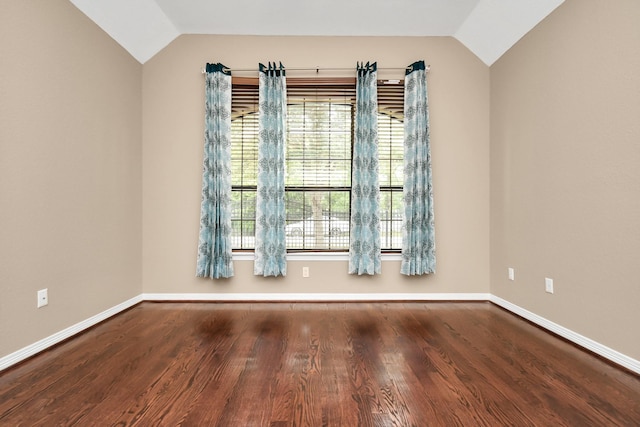 spare room with hardwood / wood-style floors, lofted ceiling, and a healthy amount of sunlight