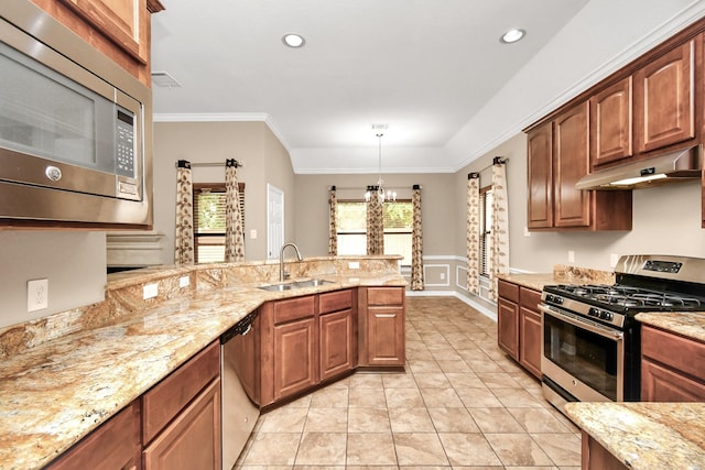 kitchen with crown molding, light stone countertops, appliances with stainless steel finishes, sink, and pendant lighting