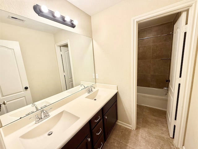 bathroom featuring vanity, tile patterned flooring, and tiled shower / bath combo