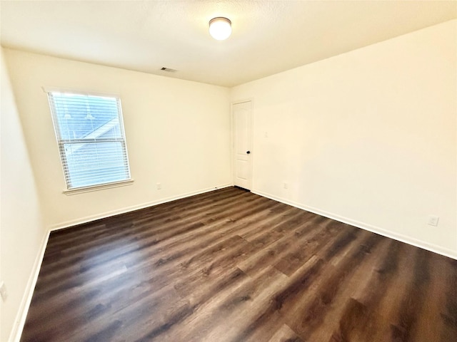 empty room featuring dark wood-type flooring