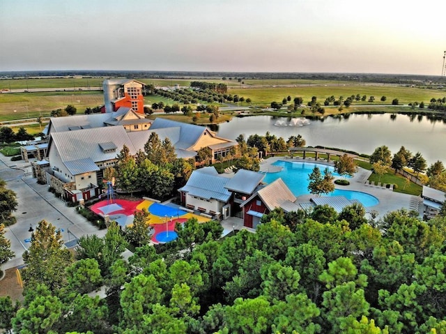 aerial view at dusk featuring a water view