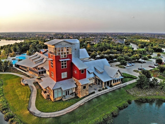 aerial view at dusk featuring a water view