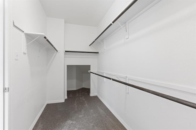 walk in closet featuring dark colored carpet