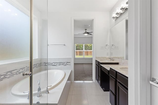 bathroom featuring vanity, tile patterned flooring, and tiled tub